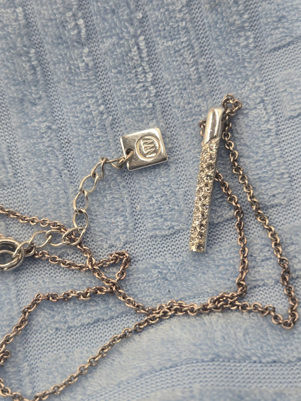 Nine West necklace features a dainty bar pendant adorned with pavé stones
